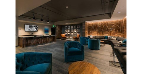 a living room with blue chairs and a bar