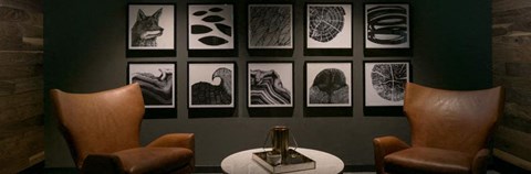 a room with a table and chairs and pictures on the wall
