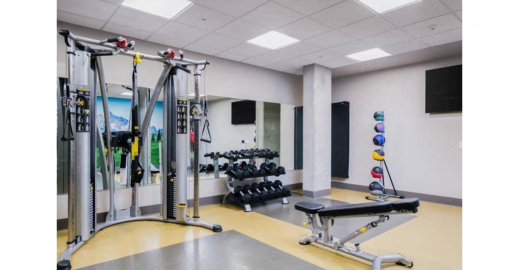the gym has a lot of weights and equipment in it