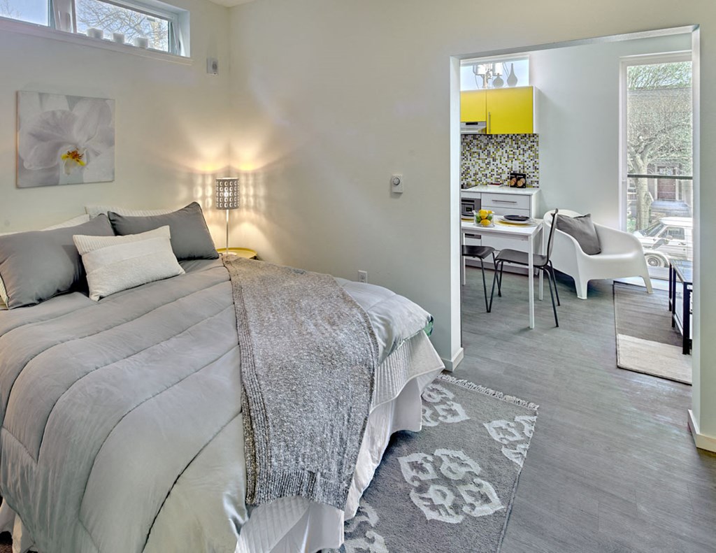 a bedroom with a bed and a living room with a desk