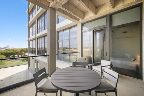 A table and chairs are set up on a balcony.