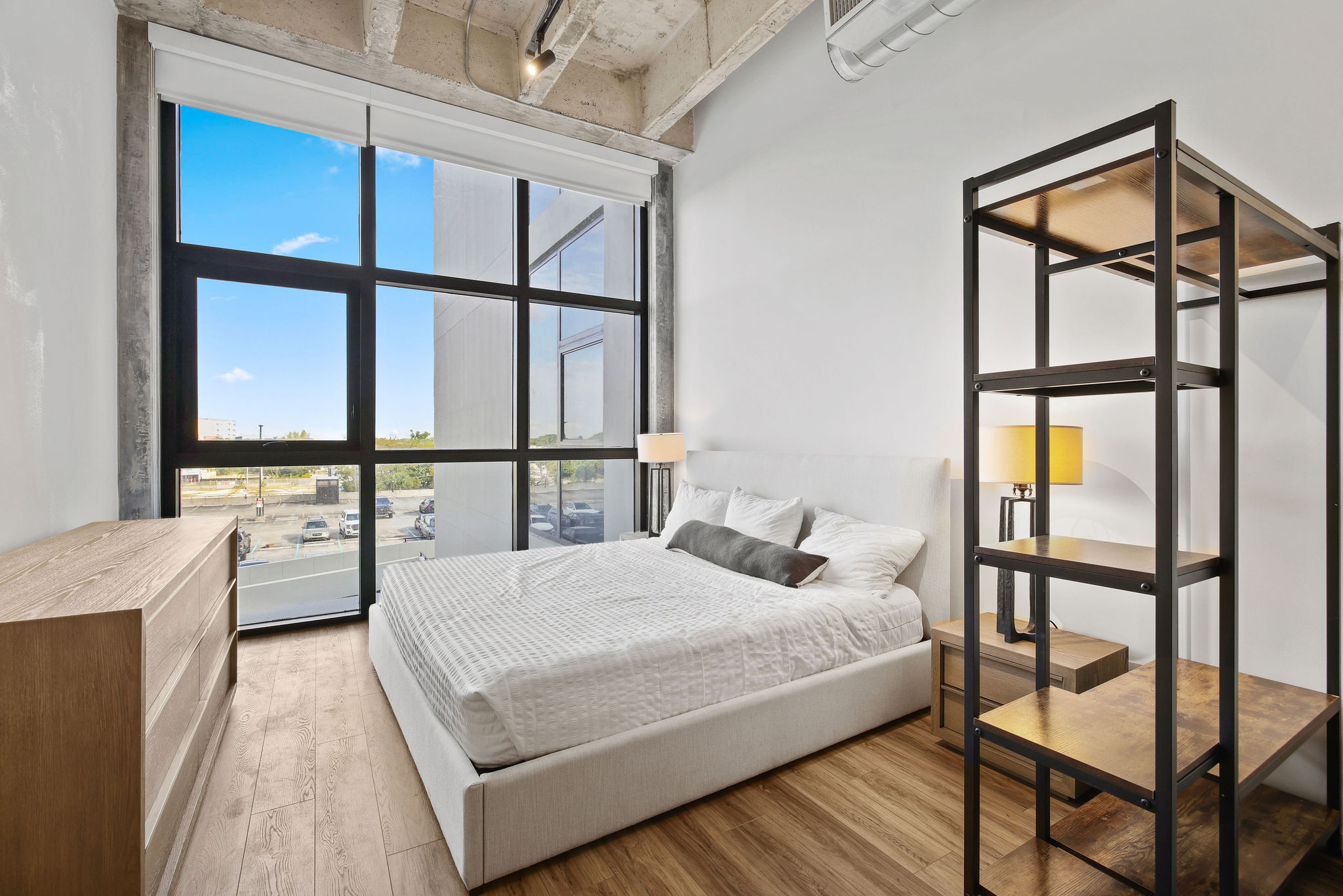 A bedroom with a large bed and a wooden cabinet.