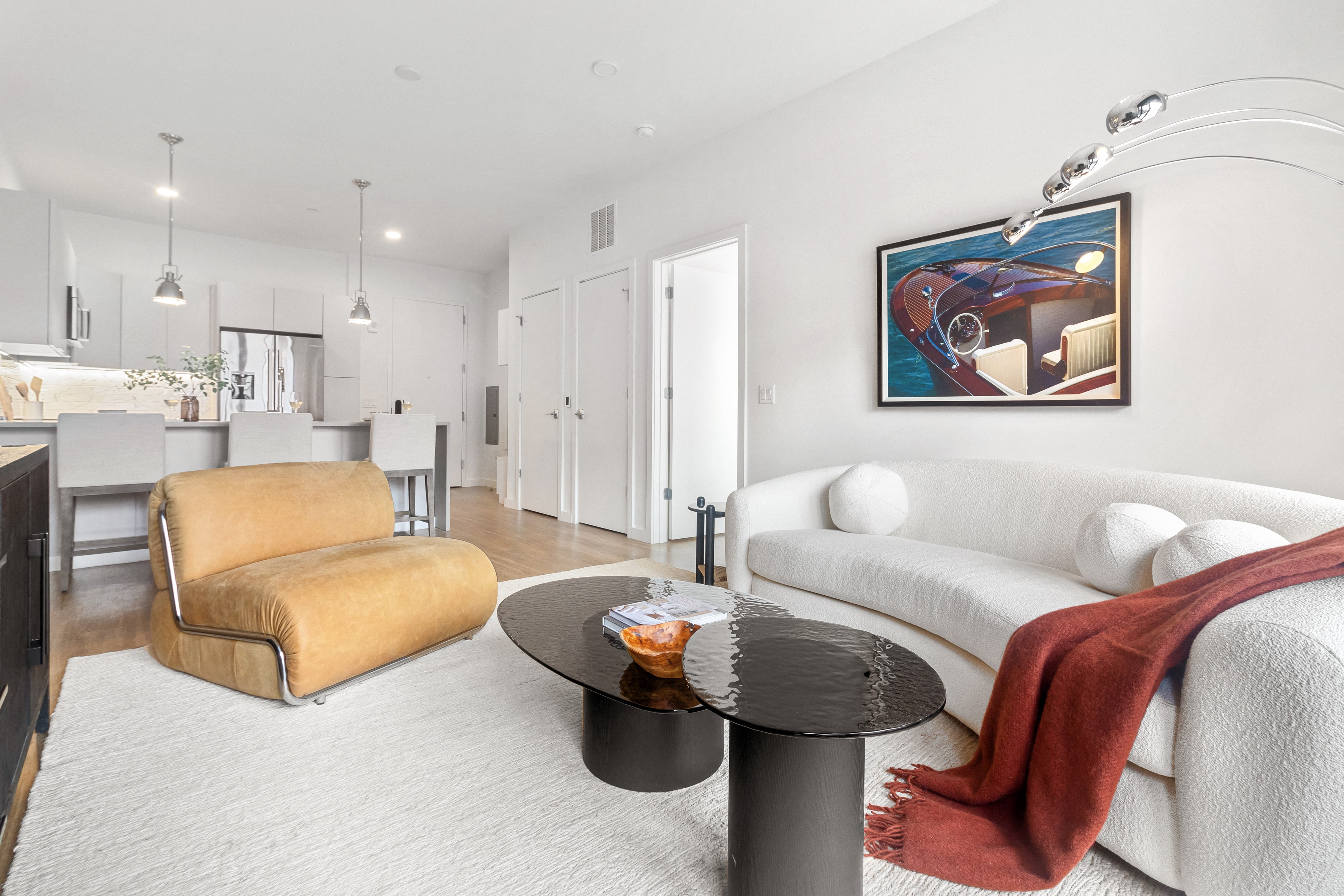A living room with a yellow chair and a white couch.