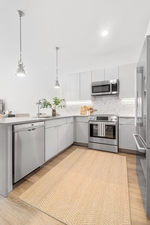 a modern kitchen with stainless steel appliances and white cabinets
