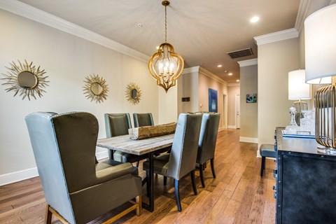 A dining room with a table and chairs.
