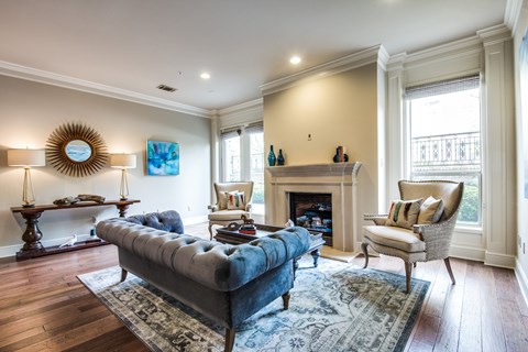 A living room with a blue couch and a fireplace.