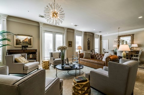 A living room with a grey sofa, a coffee table, and a chandelier.