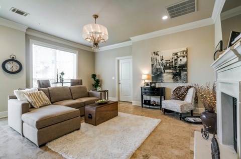 A living room with a beige couch, a coffee table, and a fireplace.