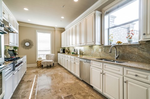 A kitchen with white cabinets and a tiled floor.