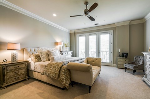 A bedroom with a large bed, a chair, and a dresser.