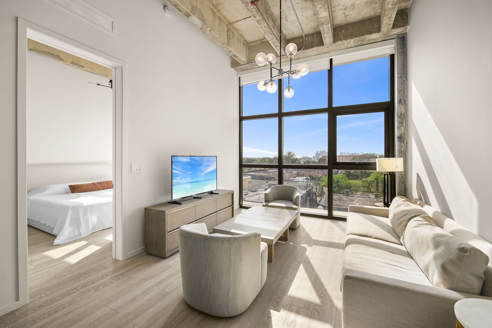 A modern living room with a large window and a flat screen TV.