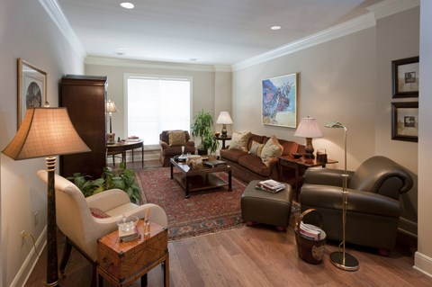 A living room with a brown leather chair and a brown lamp.