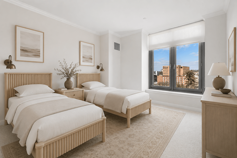 A bedroom with two beds and a window overlooking a cityscape.
