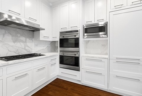 a kitchen with white cabinets and stainless steel appliances