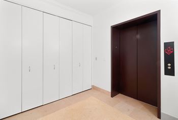 a wardrobe and a door in a white room with a tiled floor at HIGHGROVE, Stamford, Connecticut