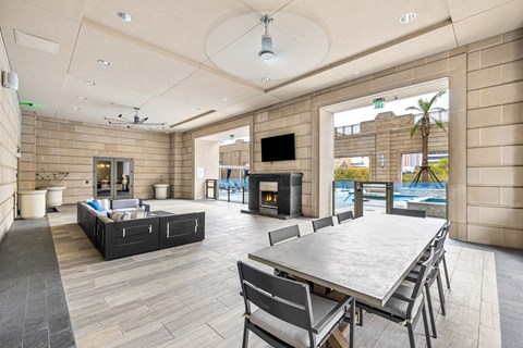 A modern outdoor dining area with a table and chairs.