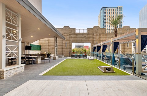 A patio area with a green lawn and a stone wall.