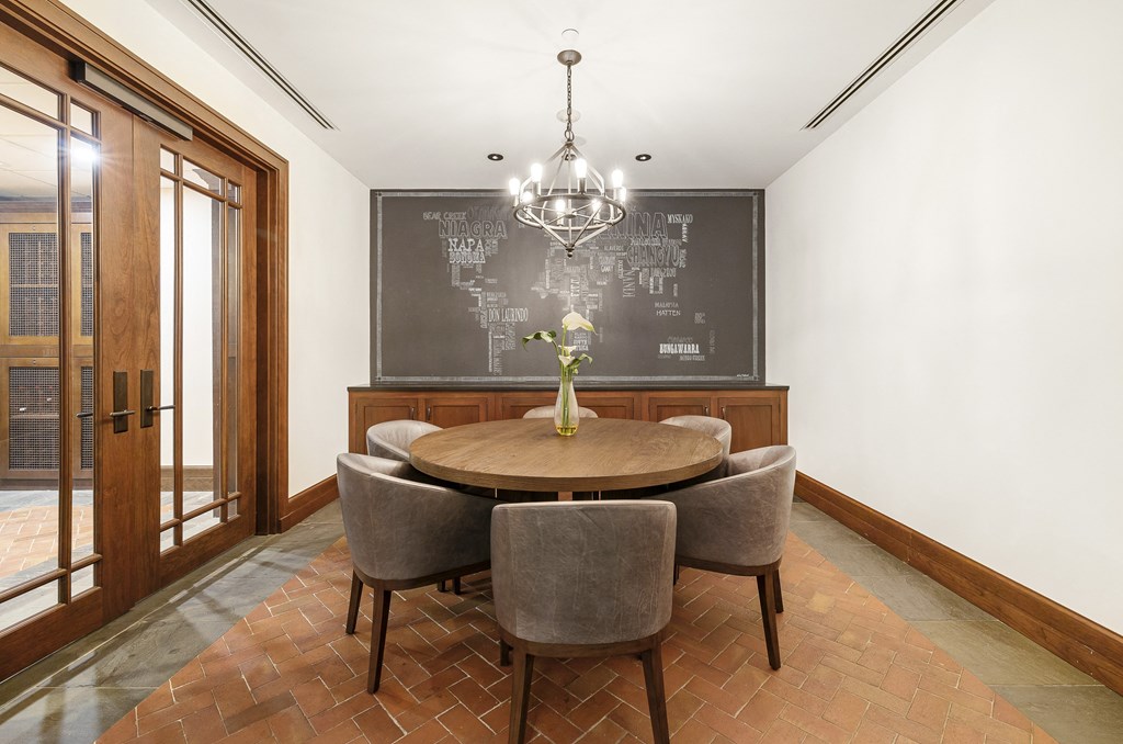 a dining room with a table and chairs and a chalkboard on the wall at HIGHGROVE, Stamford, CT, 06901