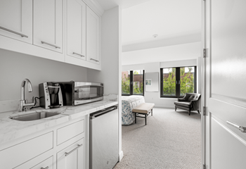a kitchen with white cabinets and a sink and a window at HIGHGROVE, Stamford, Connecticut