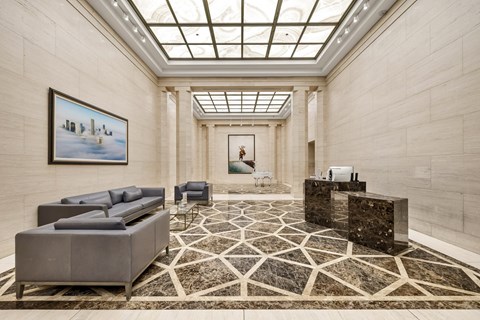 A spacious lobby with a marble floor and a skylight.