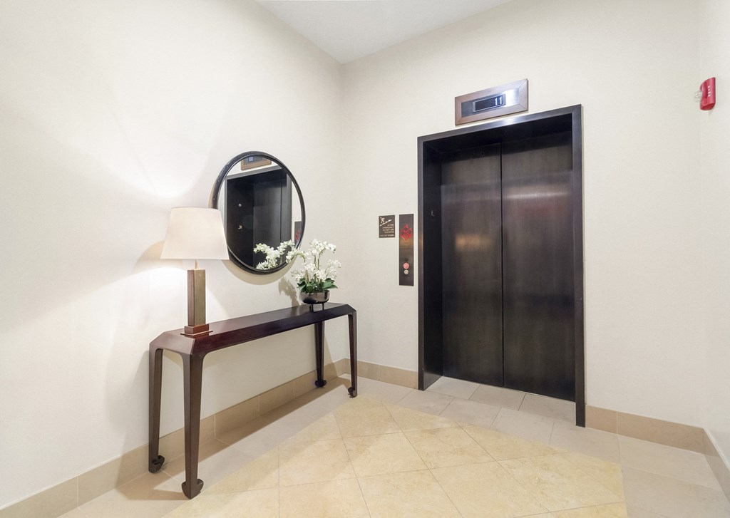 a hotel room with a mirror and a door and a elevator  at HIGHGROVE, Stamford, Connecticut