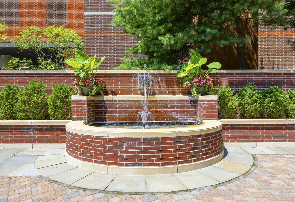 a fountain in a courtyard in front of a brick building at HIGHGROVE, Stamford, Connecticut