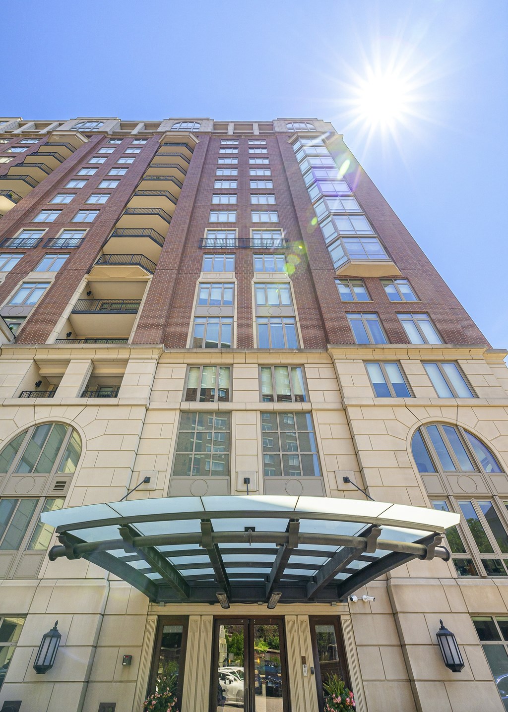 a tall building with the sun shining in front of it at HIGHGROVE, Stamford, 06901