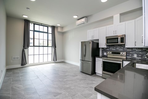 A kitchen with a refrigerator, oven, and microwave.