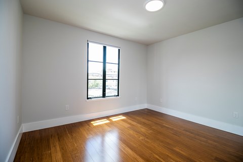 A room with a window and wooden floors.