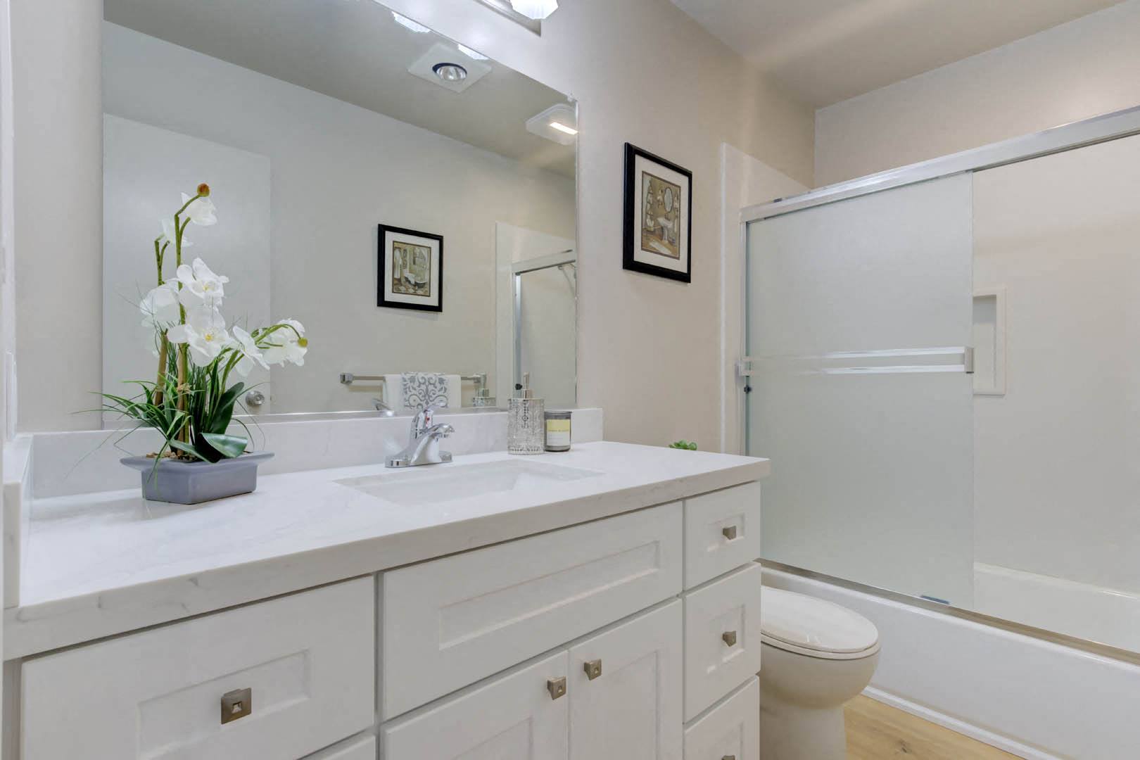 a bathroom with a white sink and toilet next to a white bathtub