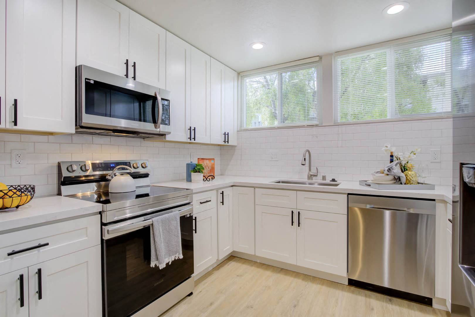 a kitchen with white cabinets and stainless steel appliances