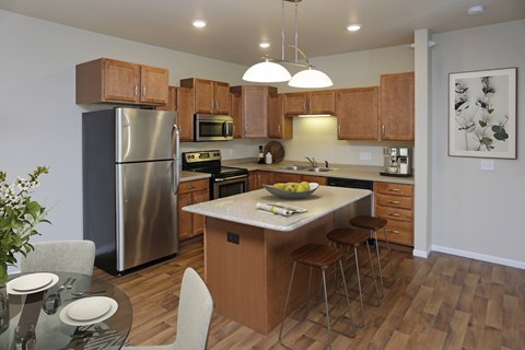 A modern kitchen with wooden cabinets and stainless steel appliances.