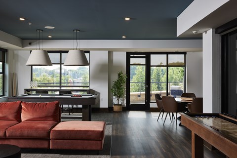A modern living room with a red couch and a dining table.