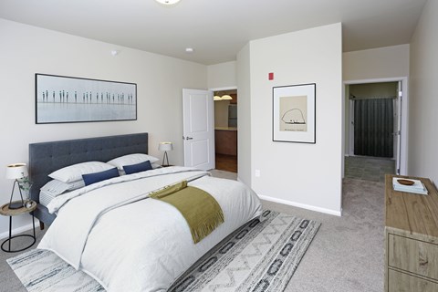 A bedroom with a large bed and a painting on the wall.