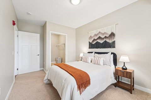 A bedroom with a large bed and a wall hanging.