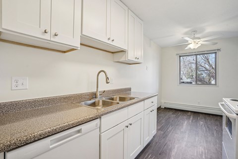 A kitchen with white cabinets and a granite countertop.