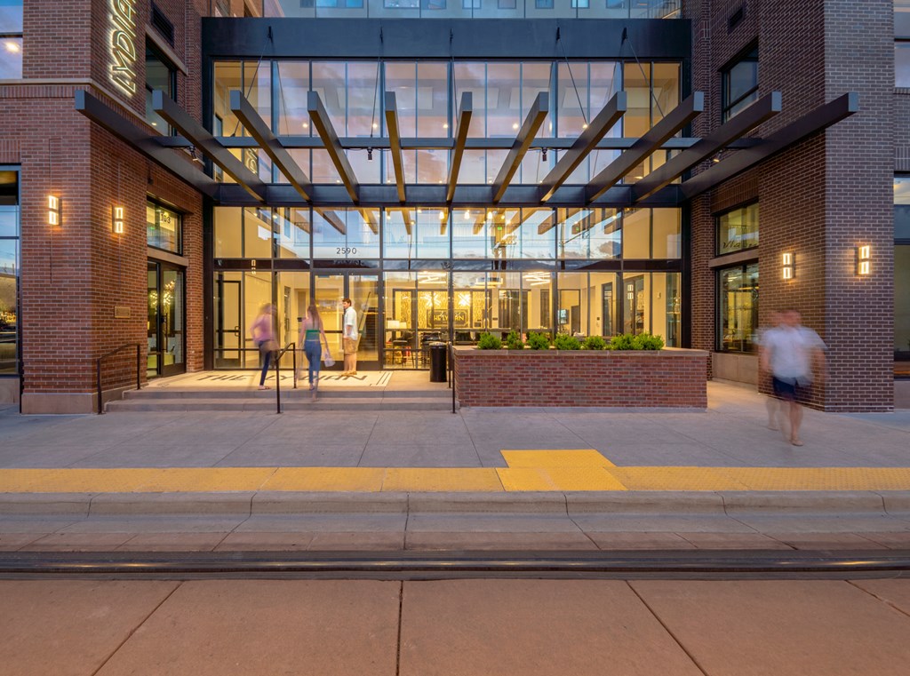 the entrance of a building with people walking in front of it