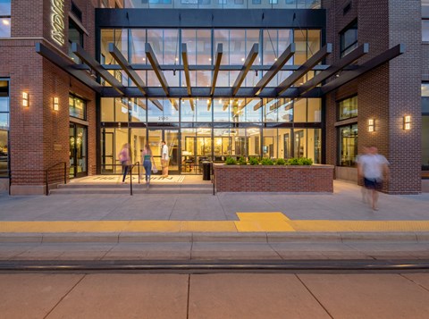 the entrance of a building with people walking in front of it