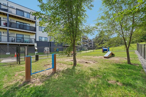 A playground with a blue swing set and a brown pole in the foreground.