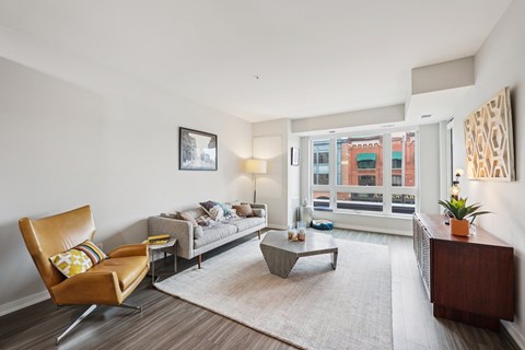 A living room with a brown leather chair and a grey sofa.