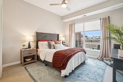 A bedroom with a large bed and a ceiling fan.