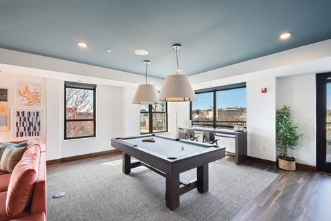 A pool table in a room with a view of the city.