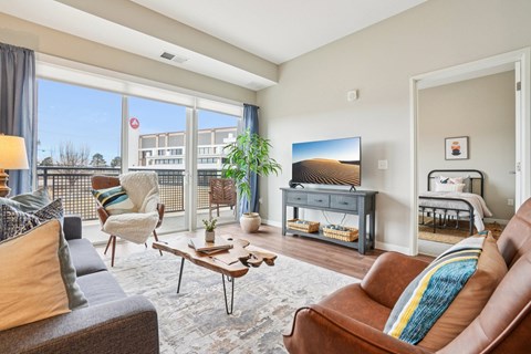 A living room with a brown leather couch and a wooden coffee table.