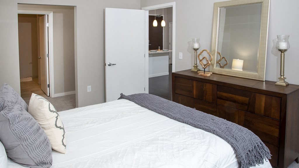 a bedroom with a bed and a dresser and a bathroom