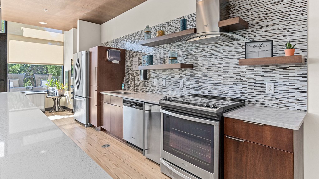 a kitchen with stainless steel appliances and a stone wall