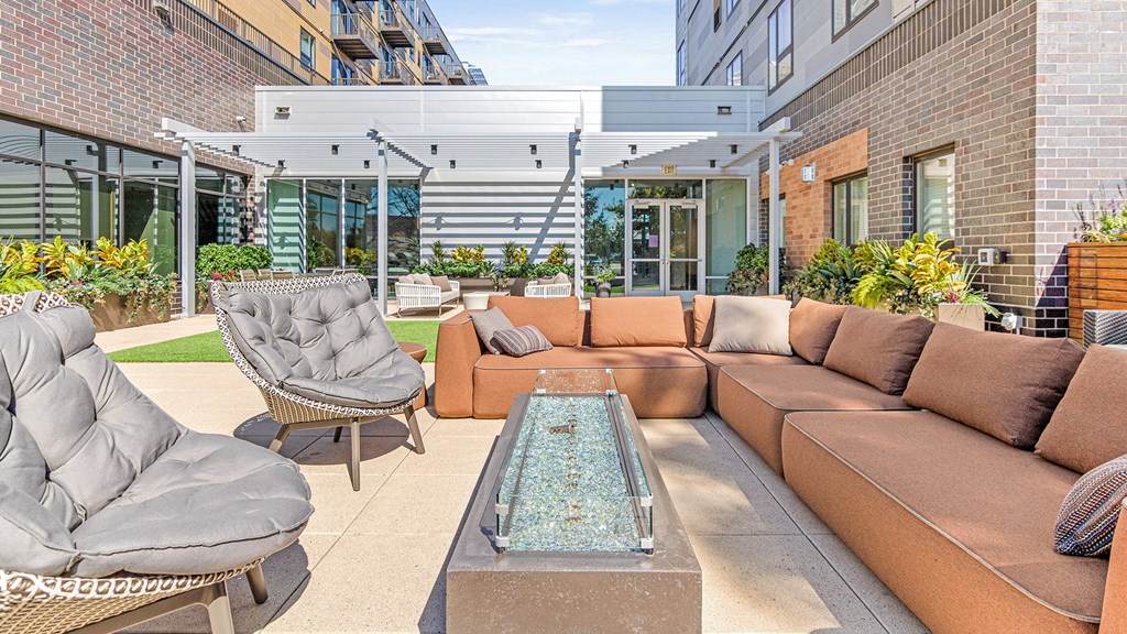 a patio with couches and chairs and a glass coffee table