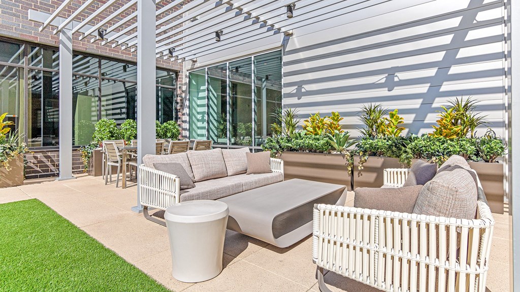 a patio with couches and a table and chairs and a glass roof