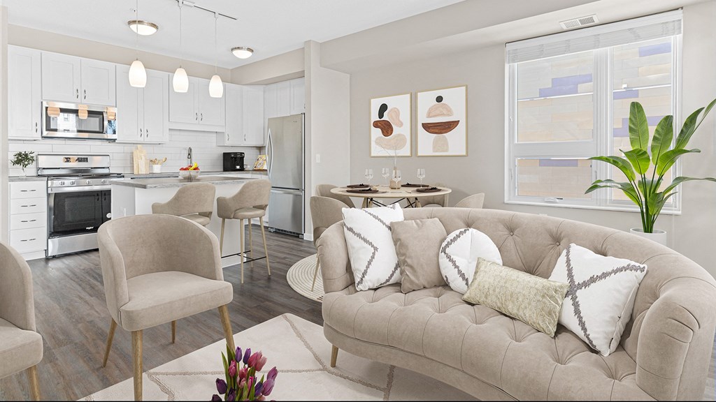 a living room and kitchen with a couch and chairs