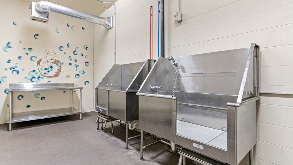 a fermentation room with three stainless steel tanks and a wall with a mural