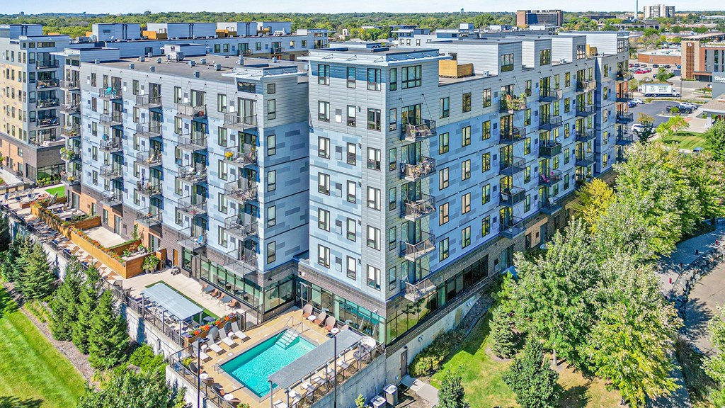 an aerial view of a building with a pool and trees
